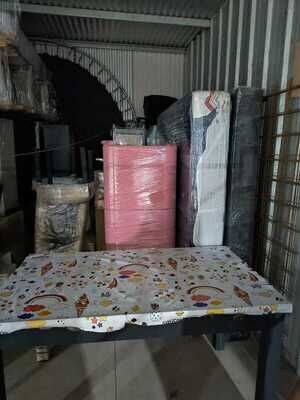 Mesa, cómoda y colchones embalados dentro de un box del guardamuebles