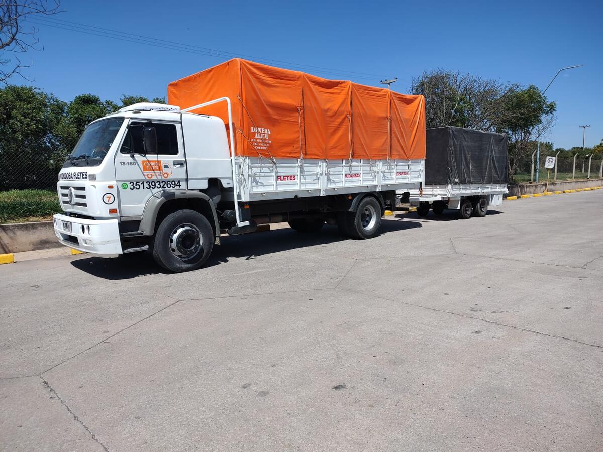 Camión con trailer de Córdoba Fletes, los dos encarpados con lona naranja