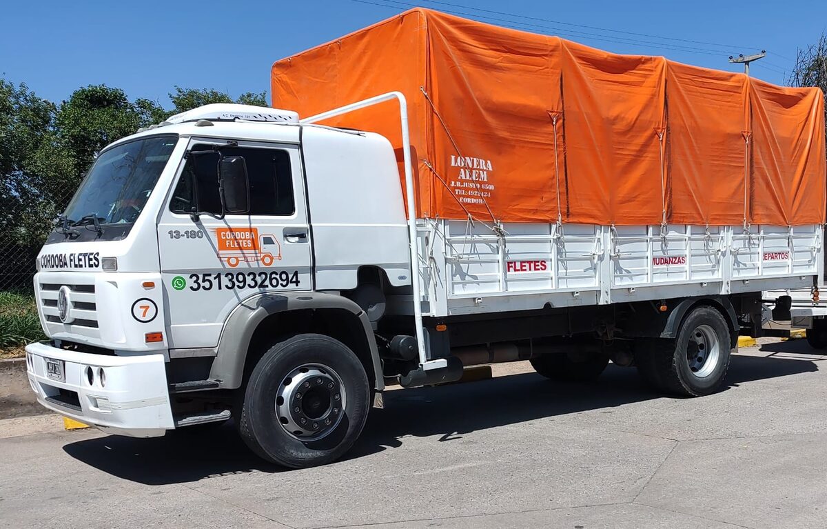 Camión de 35 m³ de Córdoba Fletes encarpado con lona naranja, listo para salir