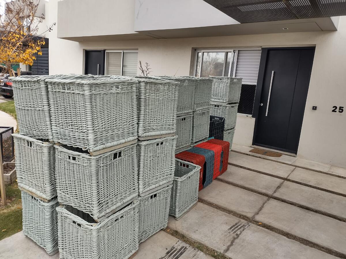 Canastos de mudanza apilados en la puerta de una casa, listos para cargar
