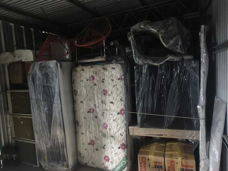 Colchón, heladera y sillas embalados dentro de un box de chapa