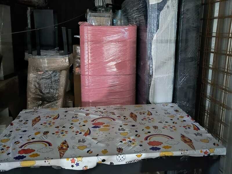 Mesa, cómoda y colchones embalados dentro de un box del guardamuebles