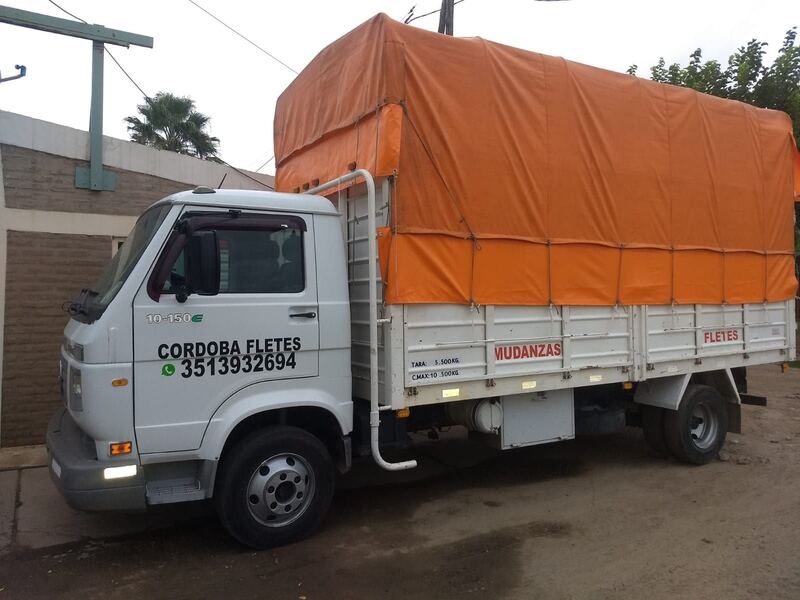 Camión de Córdoba Fletes con la caja cargada y encarpada con lona naranja