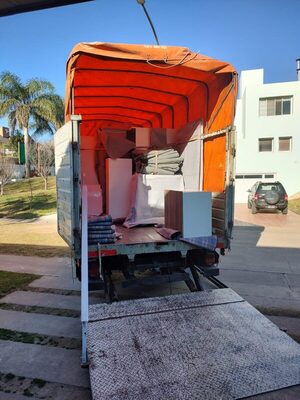 Camión de Córdoba Fletes cargado con muebles embalados, con la rampa baja