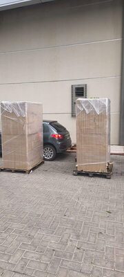 Dos pallets con muebles embalados en film en la puerta de un edificio