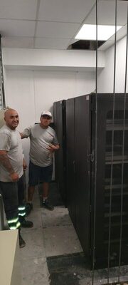 Operarios de Córdoba Fletes junto a racks de servidores en una mudanza comercial